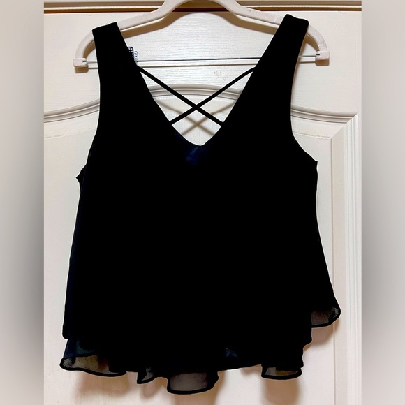 Decree Tops - Sleeveless Black tank. Gauzy material, lined, crisscross back. Size large